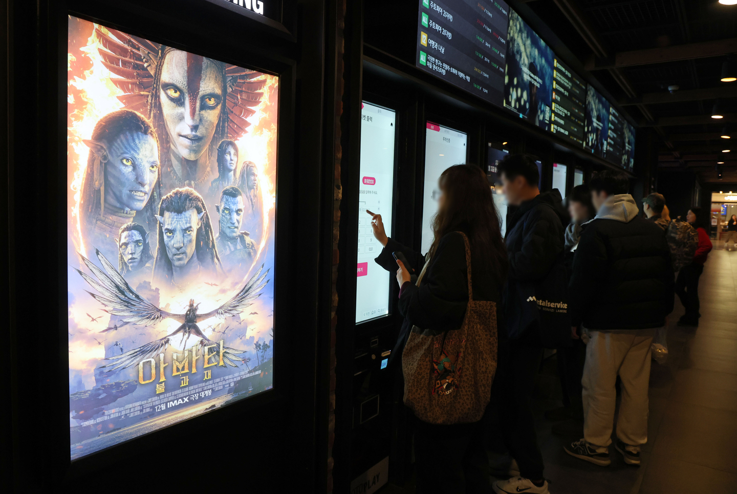 Moviegoers purchase tickets at a multiplex cinema in Seoul on Dec. 28, 2025, with a poster for Disney's ″Avatar: Fire And Ash″ displayed on a screen. [YONHAP] 