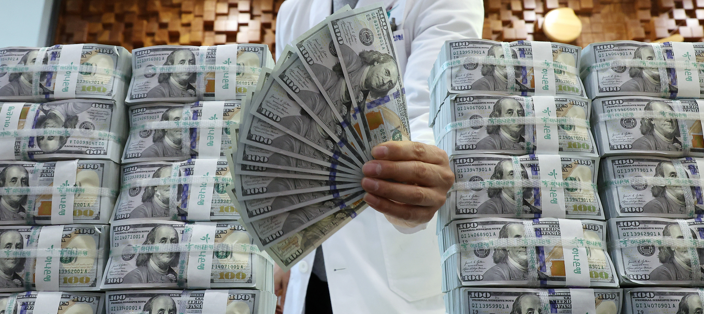 An official holds up U.S. bills at Hana Bank's counterfeit response center in Jung District, central Seoul, on Dec. 17, 2025. [YONHAP] 