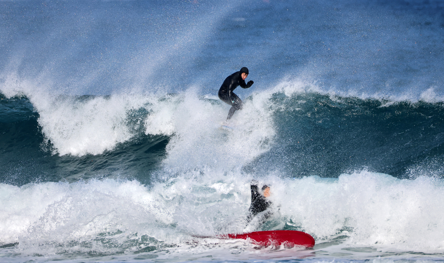 Surfers ride the waves at a beach in Yangyang County on Jan. 4, a day before  sohan , or the less cold winter period in the traditional lunar calendar. [YONHAP]