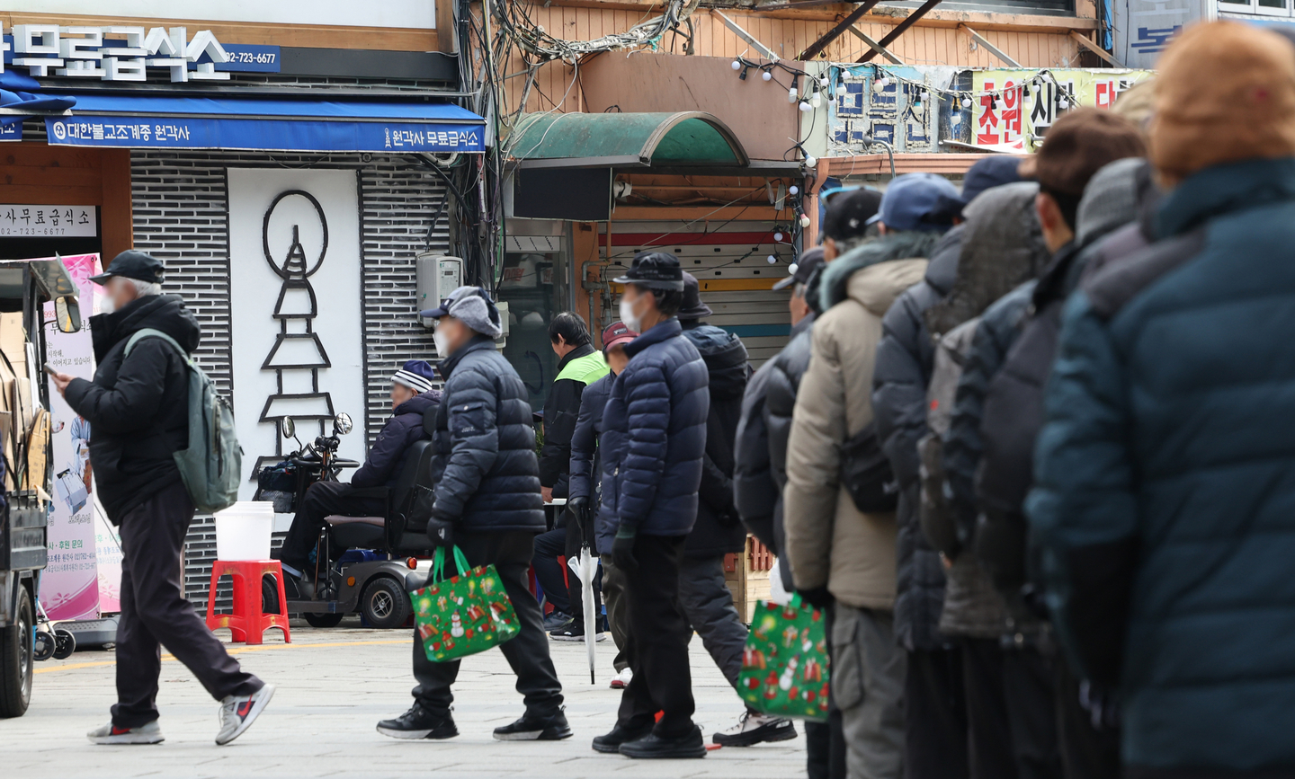 Older adults line up to get their free meal at the Tapgol Park in central Seoul on Dec. 24, 2025. [YONHAP]
