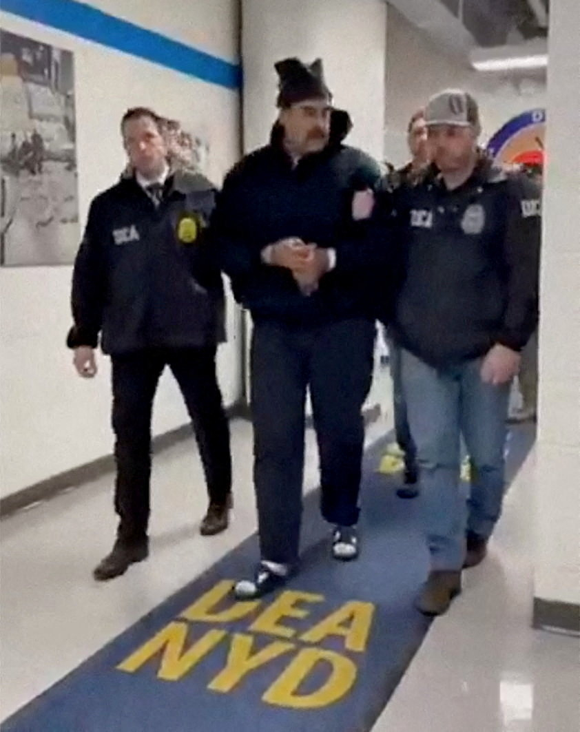 A still image from video posted by the White House's Rapid Response 47 account on X.com, which originated from the @PaulDMauro account, shows Venezuela's President Nicolas Maduro being walked in custody down a hallway at the offices of the U.S. Drug Enforcement Administration (DEA) in New York City, U.S., Jan. 3, 2026. [REUTERS/YONHAP]