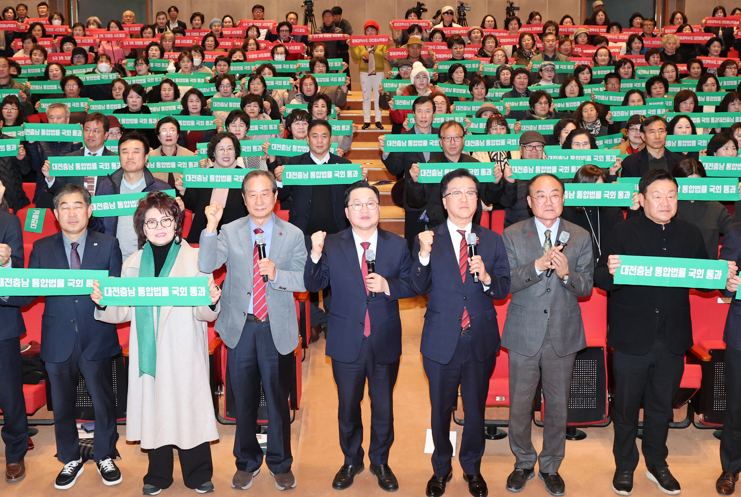 Daejeon Mayor Lee Jang-woo, center, joins attendees urging the National Assembly to pass a special law on the Daejeon-South Chungcheong administrative merger at the main auditorium of Daejeon City Hall on Dec. 12, 2025. [NEWS1]