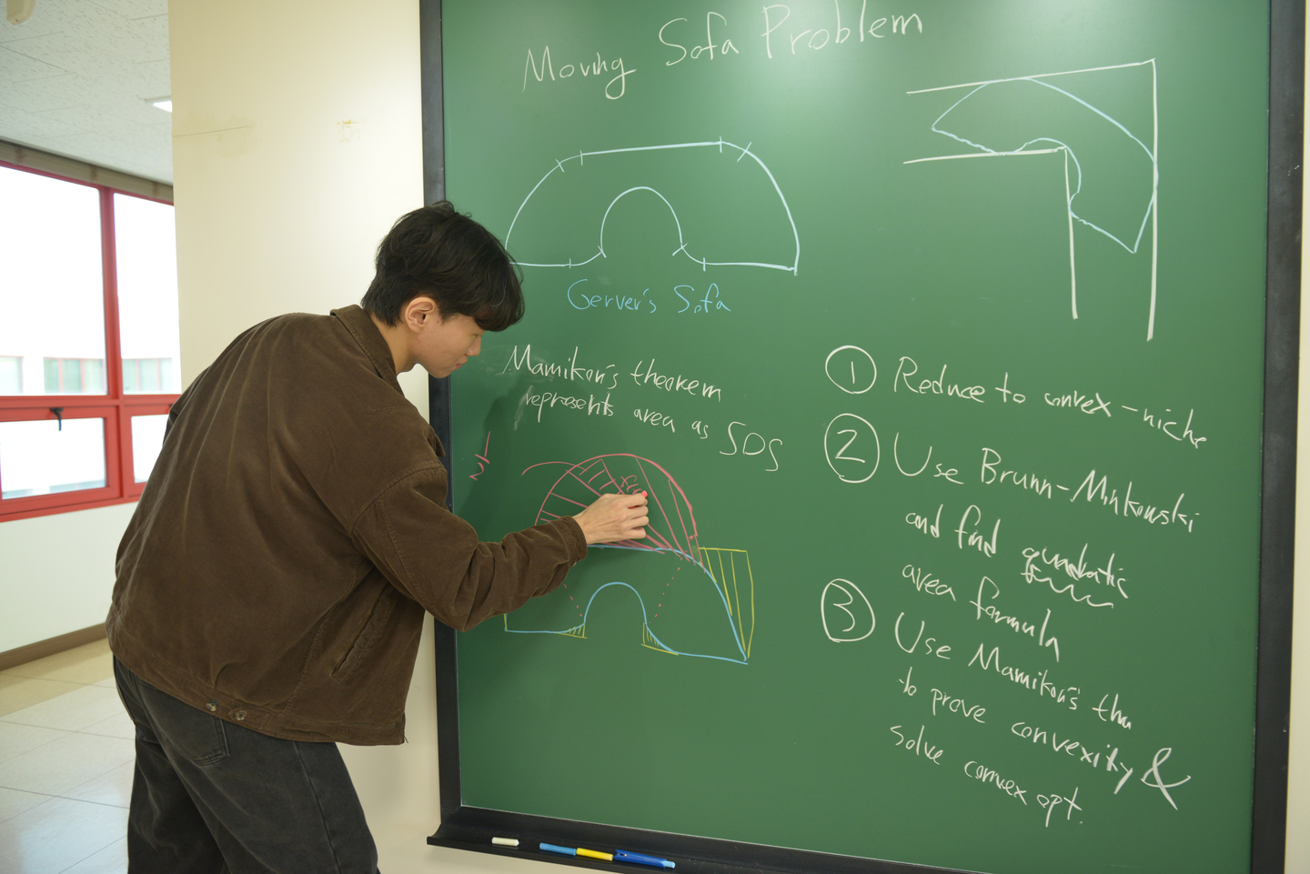 Baek Jin-eon, a researcher at the June E Huh Center for Mathematical Challenges at the Korea Institute for Advanced Study, explains the moving sofa problem. [KOREA INSTITUTE FOR ADVANCED STUDY]