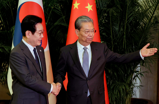 Korean President Lee Jae Myung, left, and Zhao Leji, chairman of the Standing Committee of the National People's Congress of China, head into their talks at the Great Hall of the People in Beijing on Jan. 6. [JOINT PRESS CORPS]