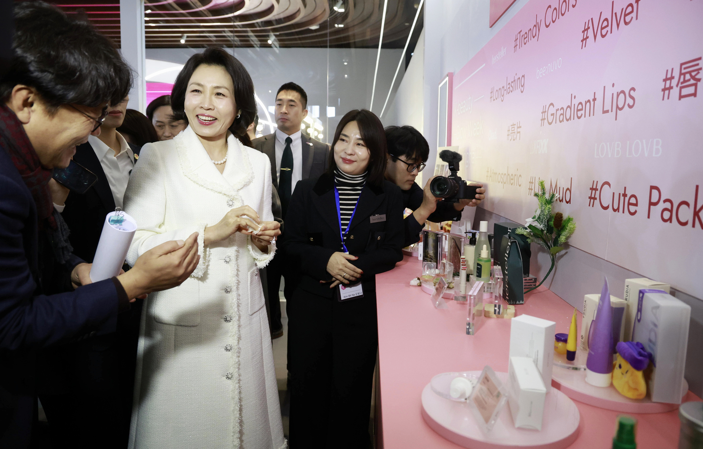 First lady Kim Hea Kyung, second from left, looks at K-beauty products in one of the booths at the “K-Beauty GLOW WEEK in Shanghai,″ held at Fosun Foundation Art Center in Shanghai, on Jan. 7. Kim accompanied President Lee Jae Myung on a state visit to China. [YONHAP] 