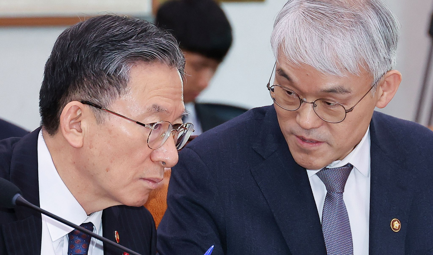 Jung Sung-ho, the Minister of Justice, left, talks with Supreme Court Justice Administration Chief Chun Dae-yup during a full session of the National Assembly’s Legislation and Judiciary Committee on the afternoon of Jan. 7 at the National Assembly. [LIM HYUN-DONG]