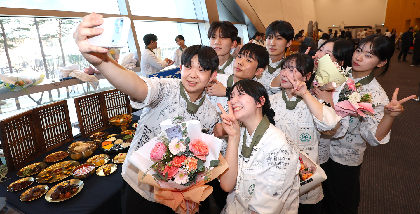  Graduates pose for selfies in front of their projects at the 25th project-based learning presentation and commencement ceremony of Korea Culinary Arts Science High School, held at Songdo Convensia in Yeonsu District, Incheon, on Jan. 8. [YONHAP] 