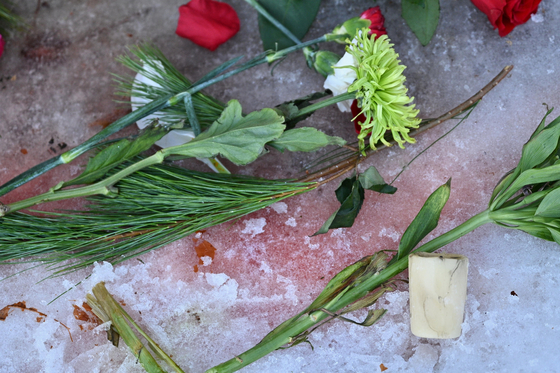 Flowers and candles are placed as protesters gather near the scene of the fatal shooting involving federal law enforcement agents on Jan. 7 in Minneapolis. [AP/YONHAP]