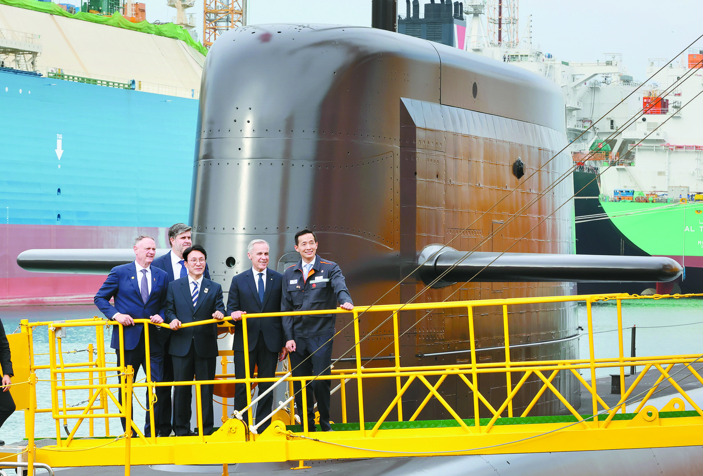Prime Minister Kim Min-seok of Korea and Canadian Prime Minister Mark Carney inspect the submarine ROKS Jang Yeong-sil at Hanwha Ocean’s Geoje shipyard in Geoje, South Gyeongsang, on Oct. 30, 2025. From left in the front row are Canadian Defense Minister David McGuinty, Prime Minister Kim, Prime Minister Carney and Kim Dong-kwan, vice chairman of Hanwha Group. [YONHAP]