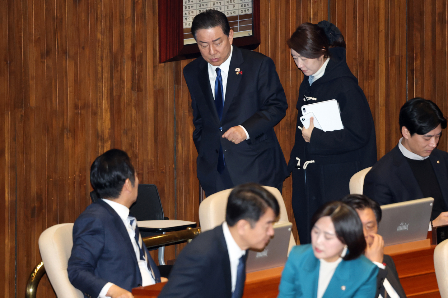 Kim Byung-kee, then floor leader of the Democratic Party, and lawmaker Kang Sun-woo, now an independent, talk as they walk during the second plenary session of the 430th extraordinary session of the National Assembly in Yeouido, Seoul, on Dec. 24, 2025. Jung Chung-rae, leader of the Democratic Party, lower left, watches them. [NEWS1]