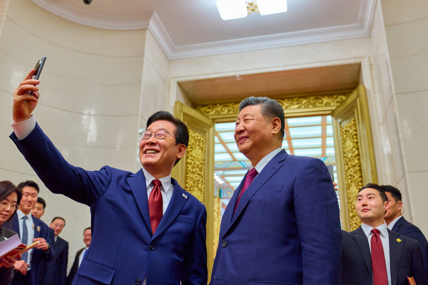 President Lee Jae Myung, left, and Chinese President Xi Jinping pose for a commemorative photo using a Xiaomi smartphone at the Great Hall of the People in Beijing on Jan. 5, following a state banquet. The phone was a gift from Xi to Lee during their summit in Gyeongju, North Gyeongsang, last year. [JOINT PRESS CORPS]