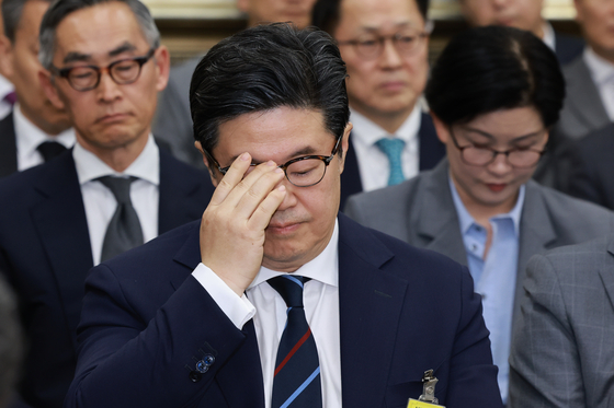 MBK Partners Chairman Michael ByungJu Kim adjusts his glasses as he appears at a National Assembly hearing in Yeouido, western Seoul, on Oct. 14, over the scandal surrounding Homeplus. [YONHAP]