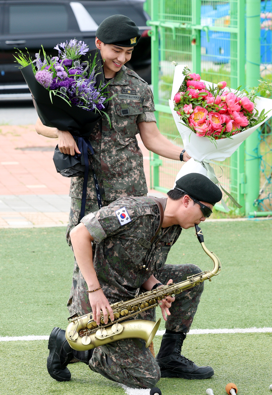 BTS members V, top, and RM, greet fans after finishing their military duties on June 11 in Yeoncheon, Gyeonggi. [NEWS1]