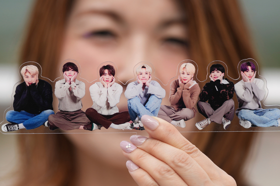 A fan poses with a group photo of BTS during a celebration marking the band's 12th debut anniversary in Goyang, Gyeonggi, on June 13, 2025. [AP/YONHAP]