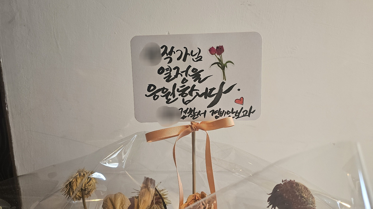 Congratulatory flowers sent by police station staff to the exhibition venue in the department’s name. [JOONGANG ILBO]