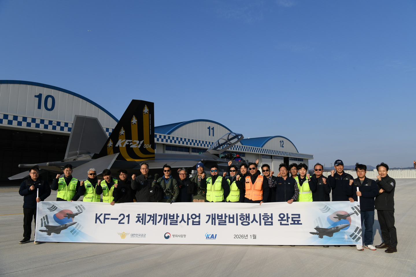 Officials pose for a group photo to mark the completion of flight tests for Korea's first homegrown KF-21 fighter jet under development on Jan. 13. [DEFENSE ACQUISITION PROGRAM ADMINISTRATION]