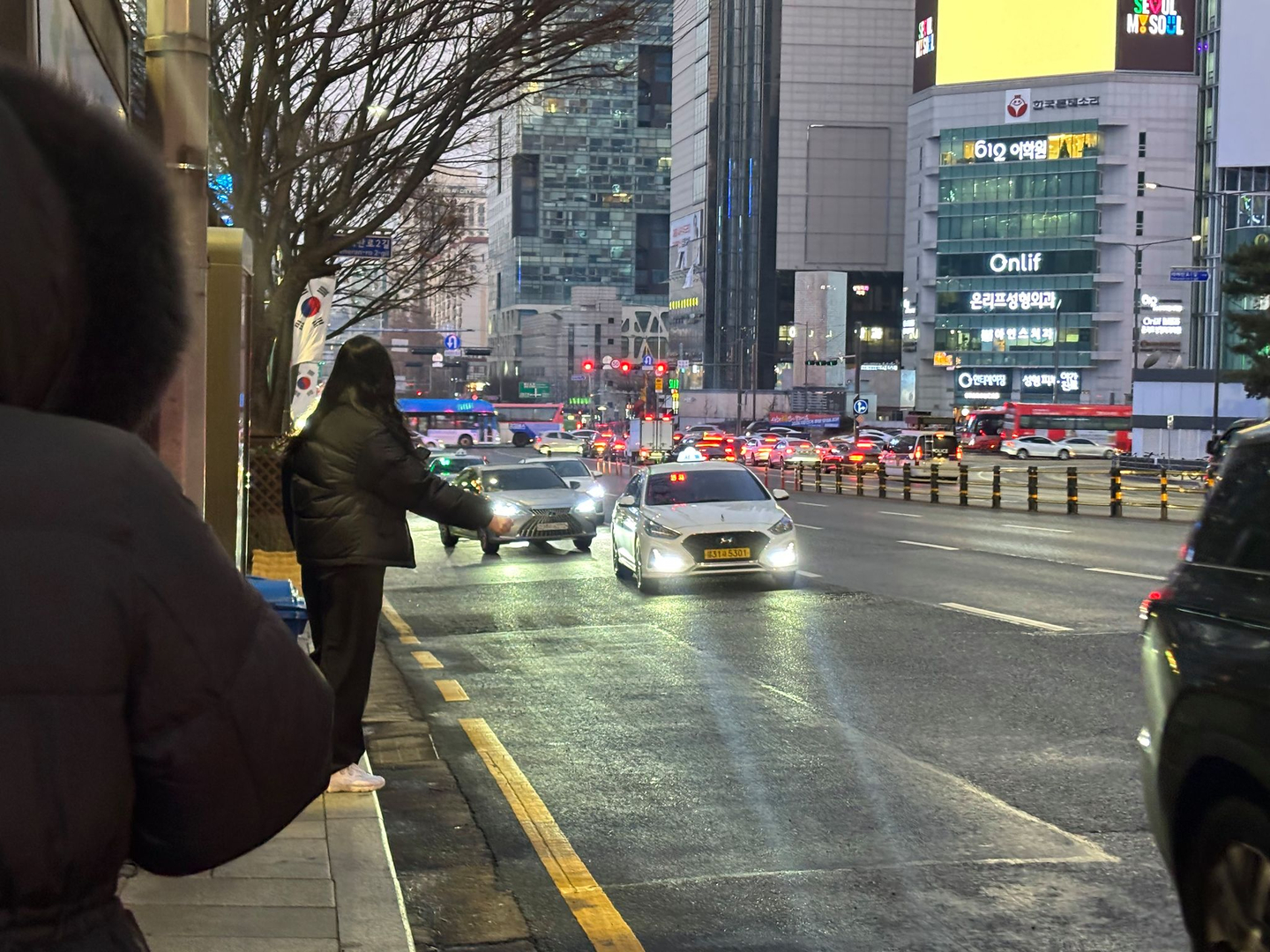 Residents hail taxis at the Gangnam Station-Yeoksam Tax Office bus stop in Gangnam District, southern Seoul, on the morning of Jan. 13. [RYU HYO-RIM]