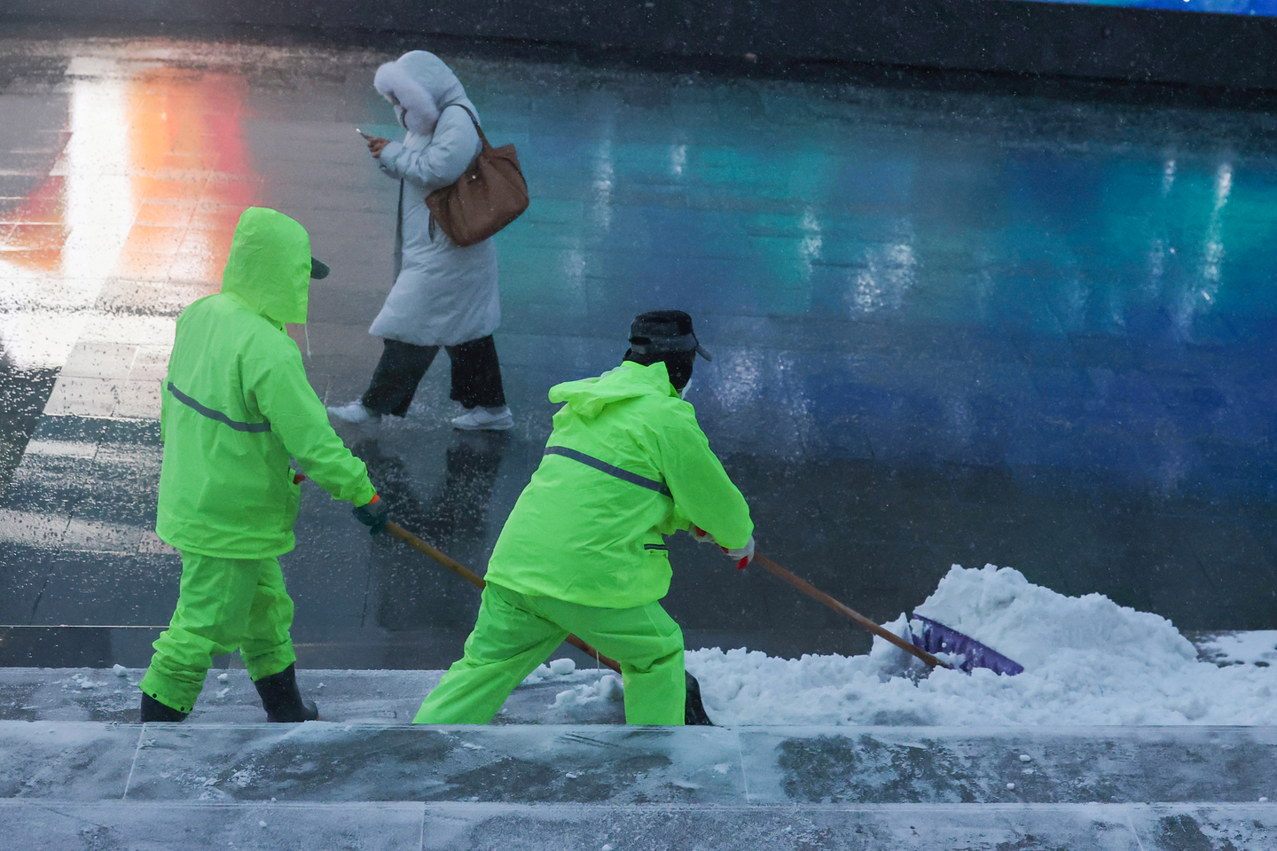 Cleaners carry out snow removal work on a street near Gwanghwamun Square in Jongno District, central Seoul on Jan. 12. [YONHAP]