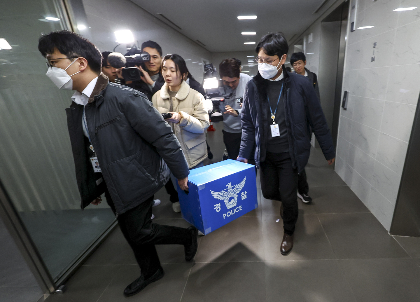Police officers carry seized materials after completing a raid at Coupang’s headquarters office in Songpa District, Seoul, on the afternoon of Dec. 9, 2025, as part of a forced investigation into a large-scale personal data leak. [JOINT PRESS CORPS]