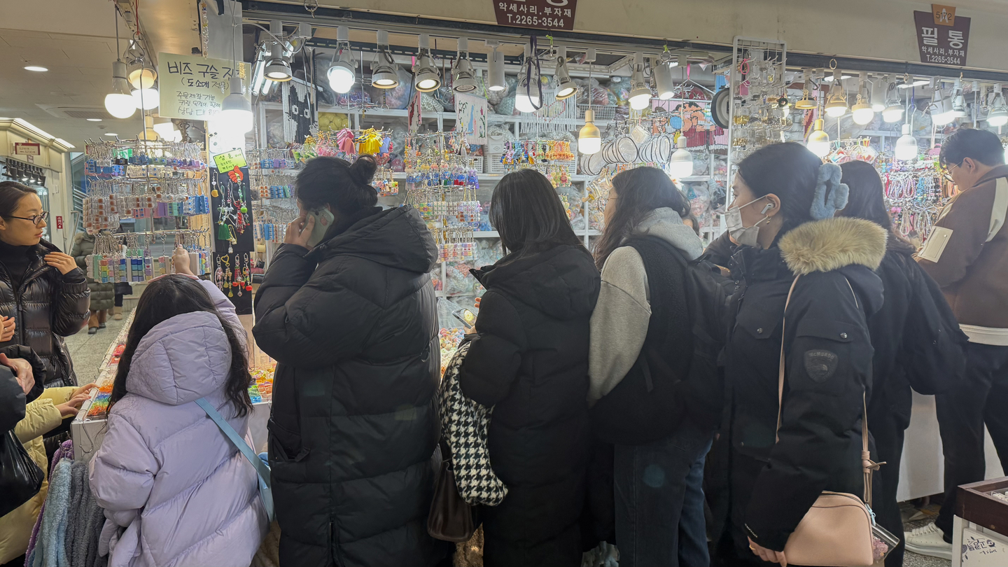 A crowd gathered around a shop selling charms for customization. [WOO JI-WON]
