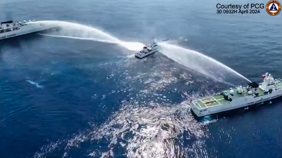 A screen capture from a video shows the Philippine Coast Guard ship BRP Bagacay being hit by water cannons from Chinese coast guard vessels near the Chinese-controlled Scarborough Shoal in the disputed waters of the South China Sea. [PHILIPPINE COAST GUARD, AFP/YONHAP]