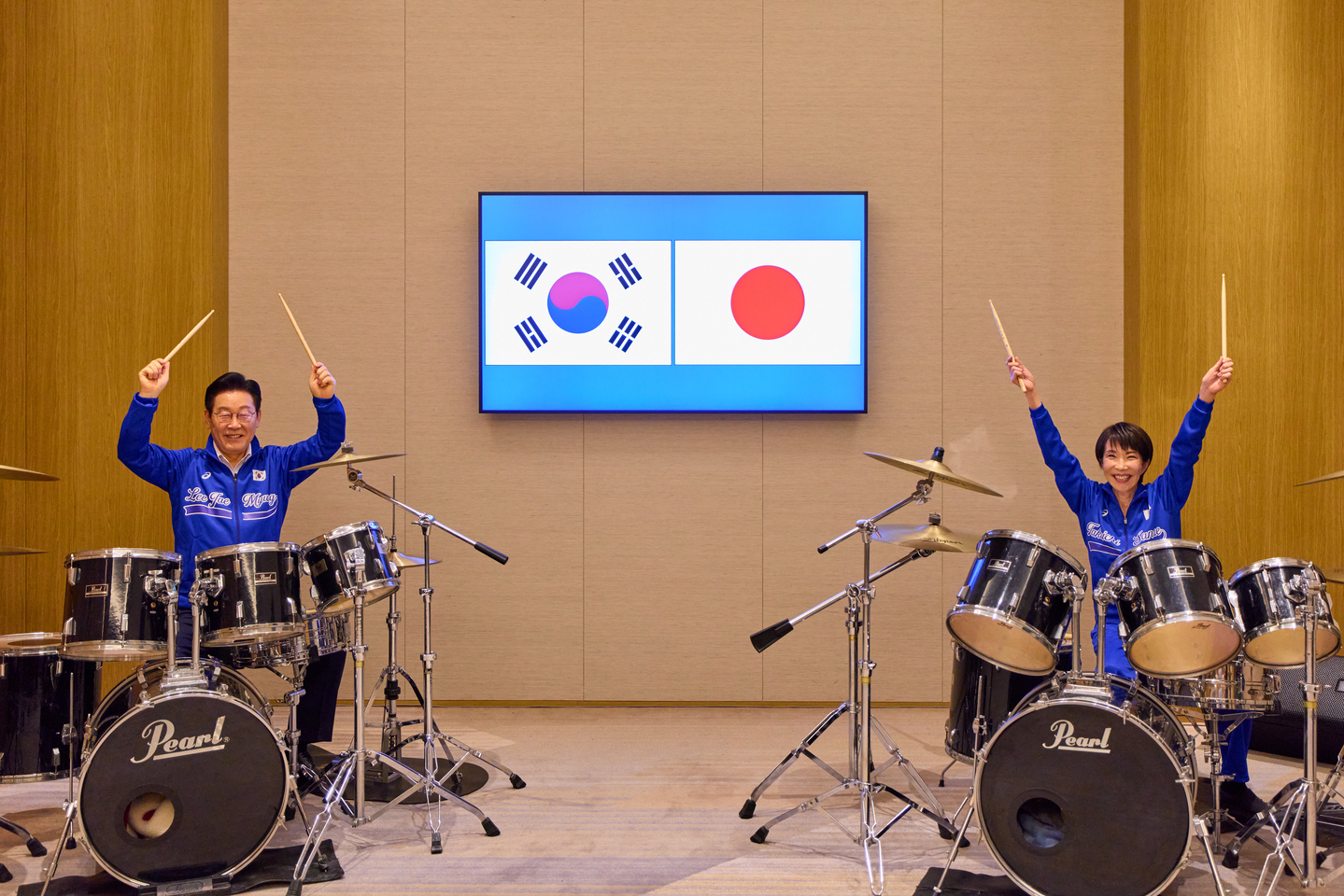 President Lee Jae Myung, left, and Japanese Prime Minister Sanae Takaichi don matching jackets and play a drum duet in Nara, Japan, on Jan. 13. The surprise K-pop drum performance, featuring BTS’s hit “Dynamite,” capped their summit with a show of personal rapport and future-oriented cooperation. [JOINT PRESS CORPS]