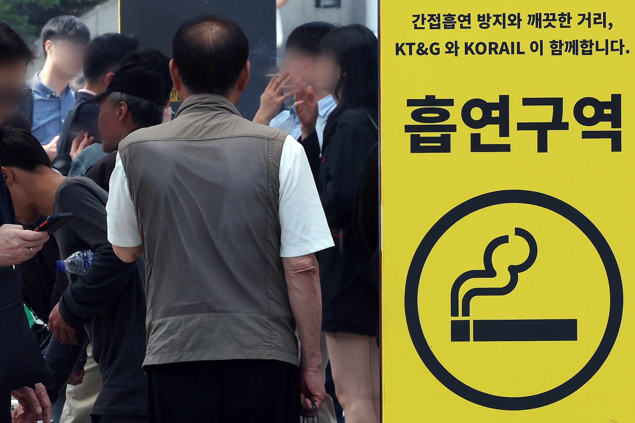 Smokers gather at a smoking zone on May 29 in Seoul. [NEWS1]