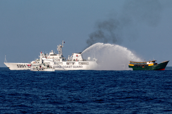 Chinese Coast Guard vessels fire water cannons towards a Philippine resupply vessel Unaizah on its way to a resupply mission at Second Thomas Shoal in the South China Sea, March 5, 2024. [REUTERS/YONHAP]