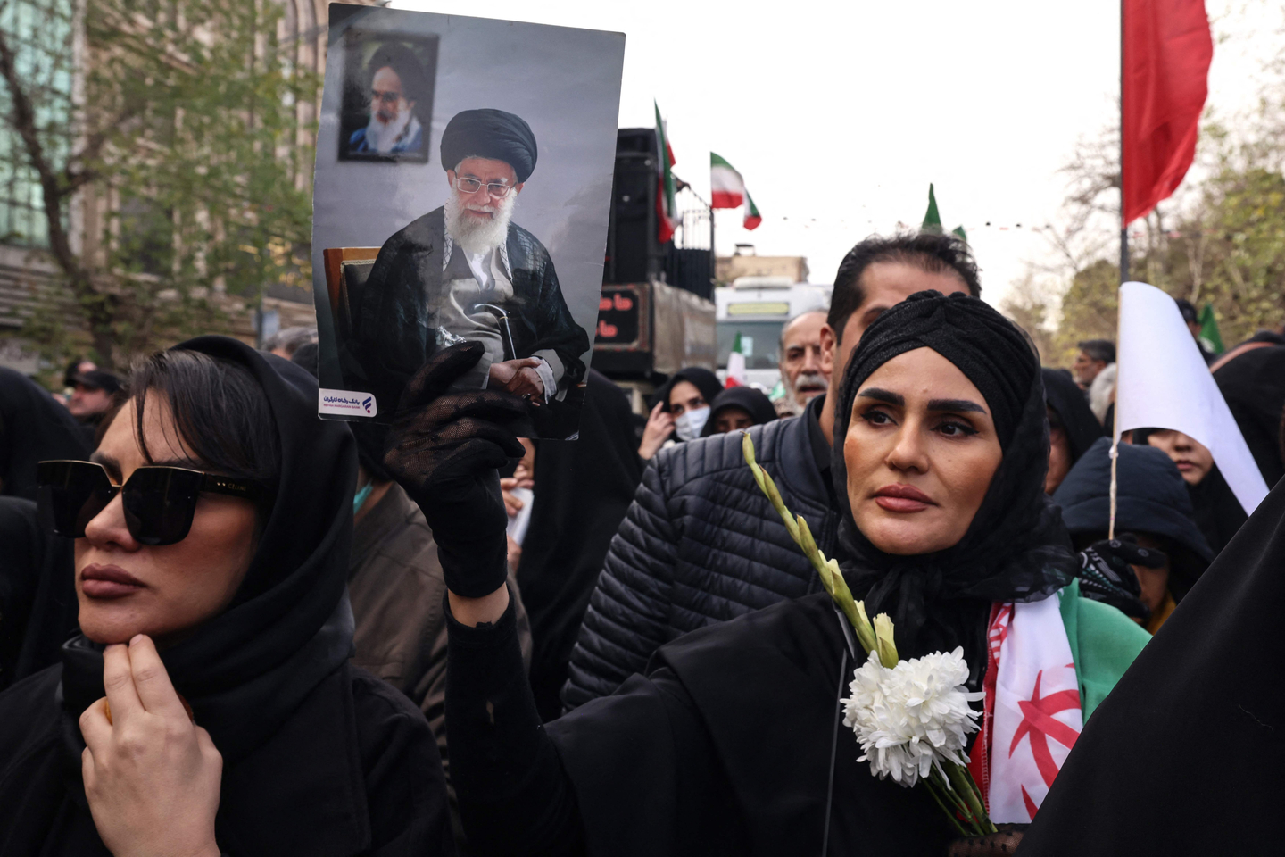 An Iranian woman holds a portrait of Iran's Supreme Leader Ayatollah Ali Khamenei during the funerals of security forces personnel killed in recent protests in Tehran on Jan. 14, 2026. [AFP/YONHAP]