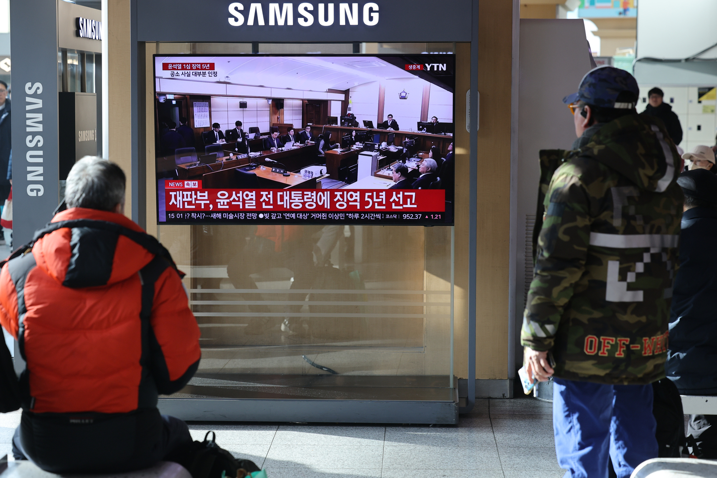 People watch a news broadcast showing former President Yoon Suk Yeol's being sentenced to five years in prison for charges including obstruction of arrest, at Seoul Station in Yongsan District, central Seoul, on Jan. 16. [NEWS1]