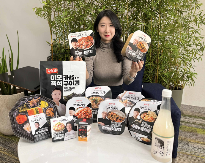 A model holds up GS25 convenience store products with the Netflix cooking reality show ″Culinary Class Wars″ (2024–) intellectual property brand. [GS RETAIL]