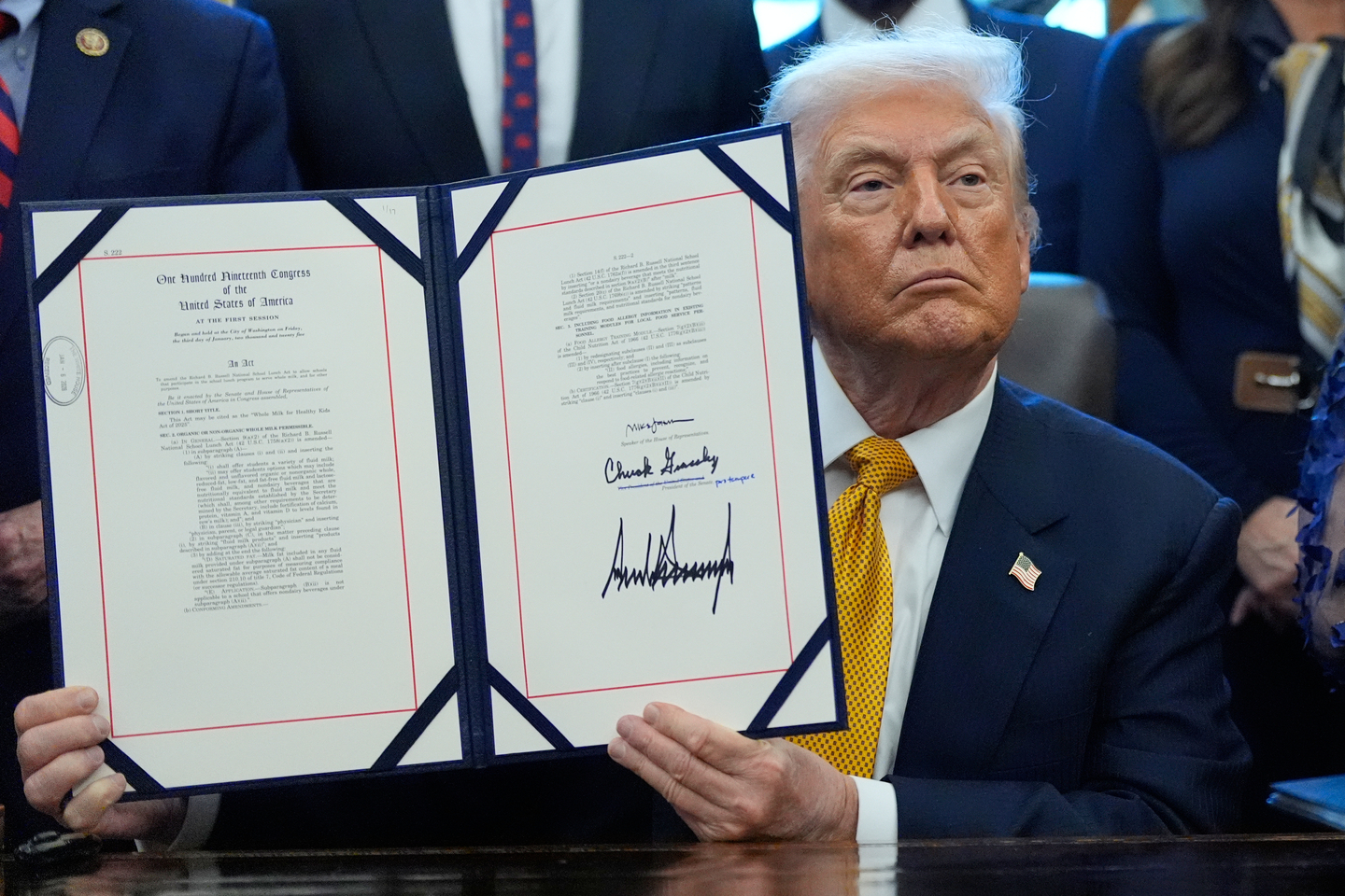 U.S. President Donald Trump holds a bill that returns whole milk to school cafeterias across the country, in the Oval Office of the White House on Jan. 14, in Washington. [AP/YONHAP]