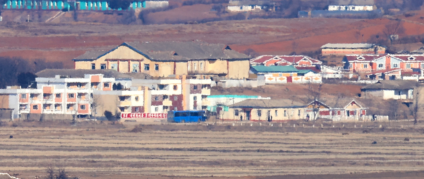 A bus moves through a village in Kaepung County, North Hwanghae Province, as seen from the Ganghwa Peace Observatory in Incheon on Jan. 11. [YONHAP]