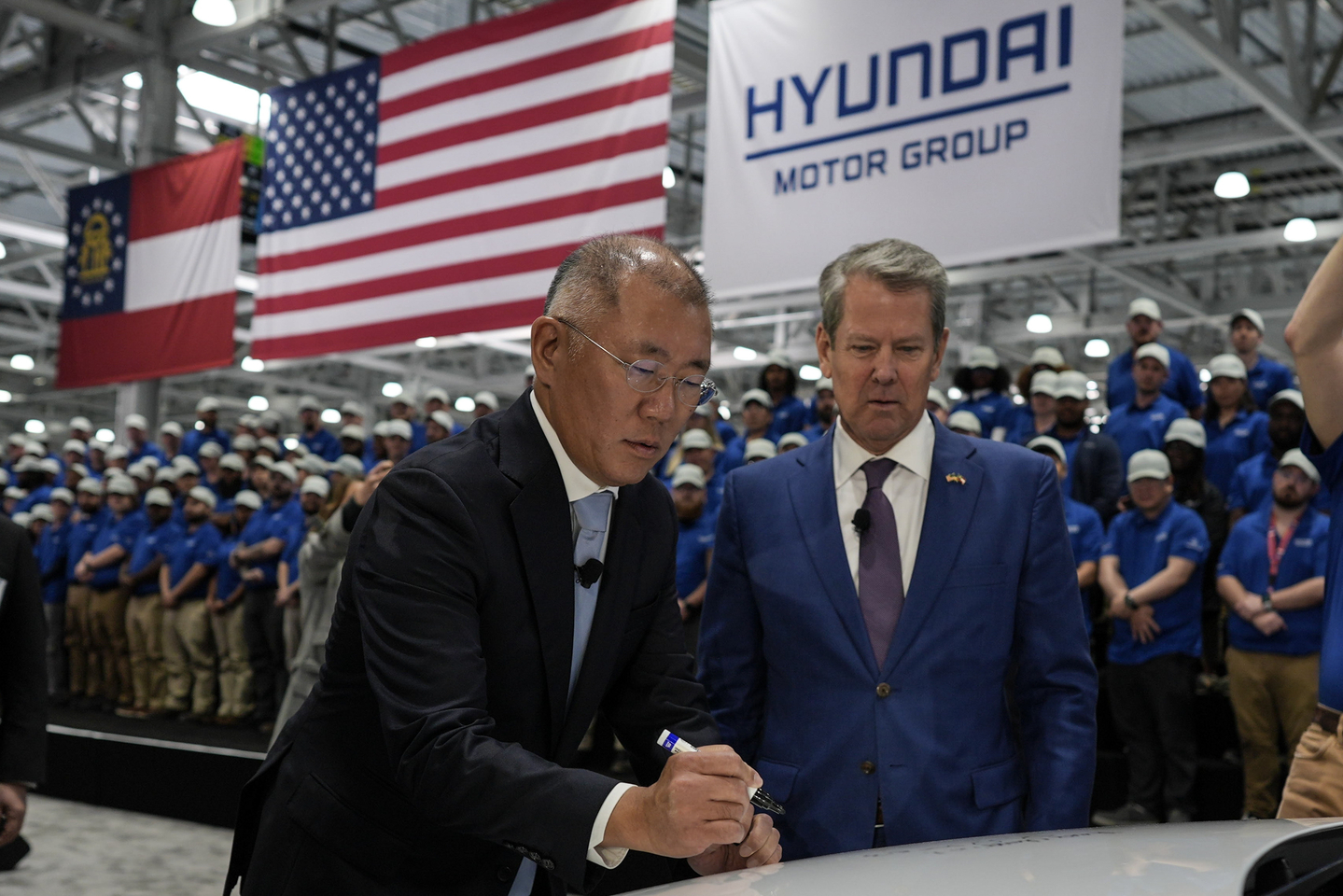Euisun Chung, Executive Chair of Hyundai Motor Group, left, stands with Georgia Gov. Brian Kemp as Chung signs an Ioniq 9 EV vehicle during a media tour and grand opening at the Hyundai Motor Group Metaplant America on March 26, 2025, in Ellabell, Georgia. [AP/YONHAP]
