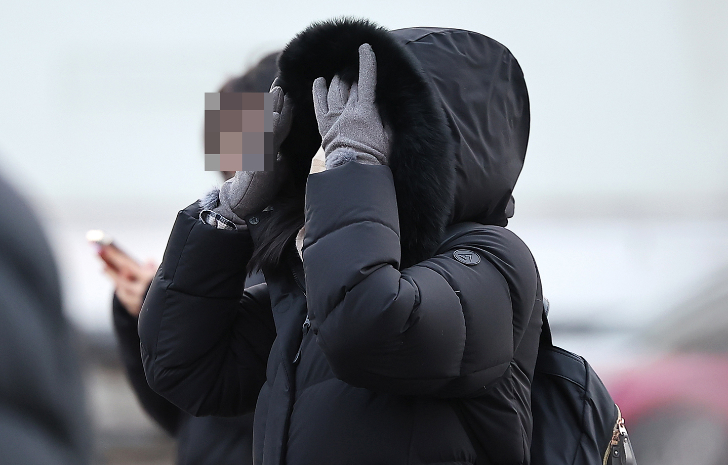 A pedestrian walks across Gwanghwamun Square in central Seoul with a thick coat and gloves on Jan. 5. [NEWS1]