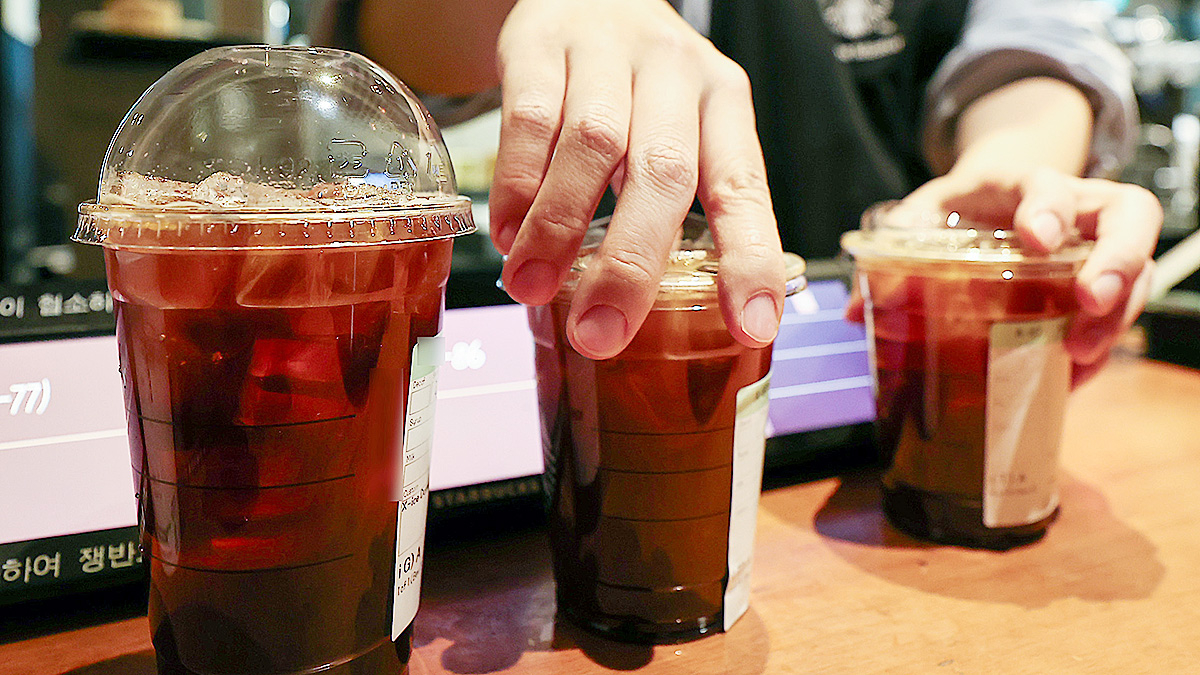 A cafe employee sorts plastic cups of cofee at a cafe in Seoul on Dec. 18, 2025. [NEWS1]