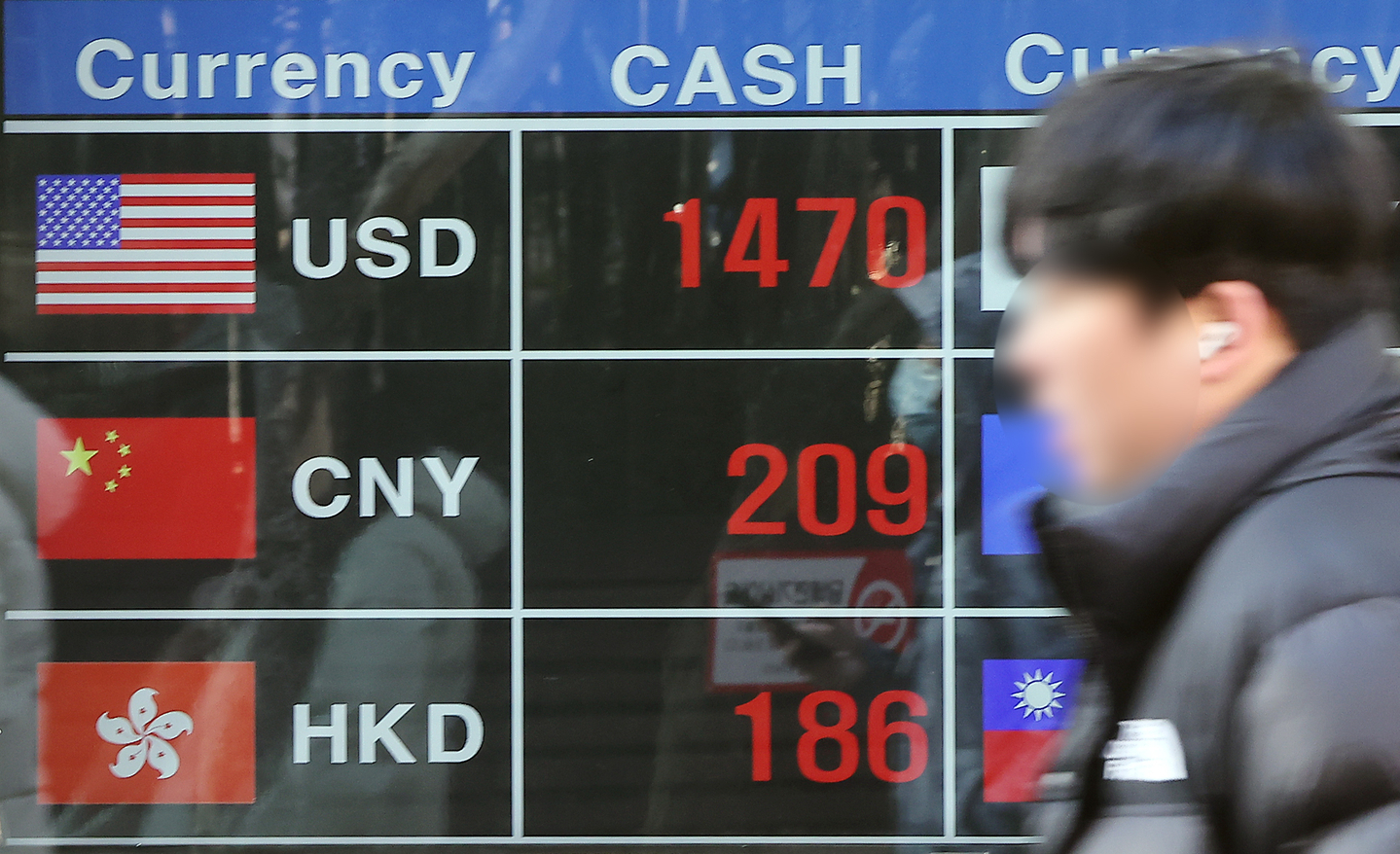Exchange rates for the won against the U.S. dollar, Chinese yuan and Hong Kong dollar are displayed on a screen at a currency exchange in Myeongdong, central Seoul, on Jan. 13. [NEWS1] 