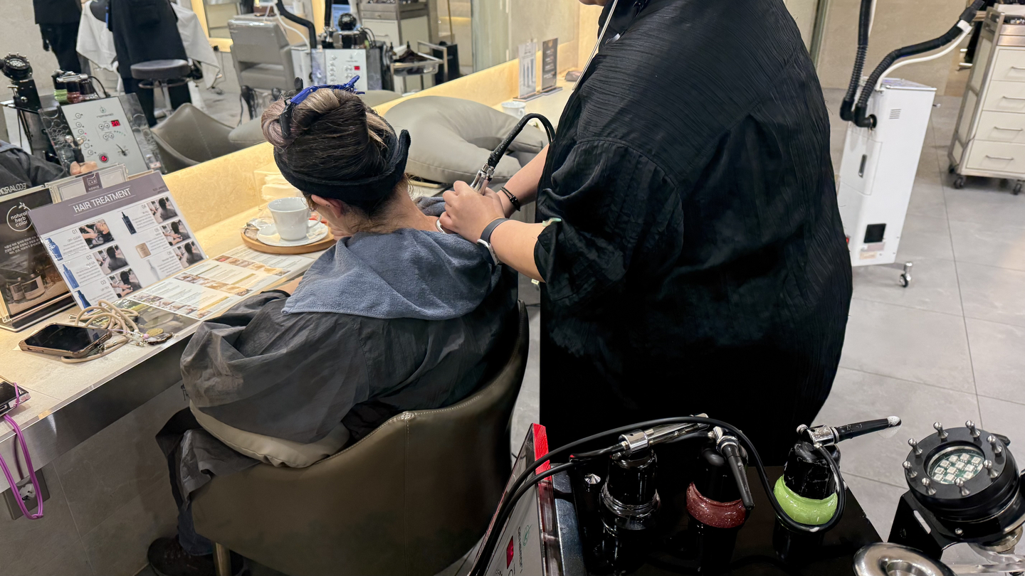 An overseas customer receives a shoulder massage using a massage device at hair salon EcoJardin in Songpa District, southern Seoul. [WOO JI-WON]
