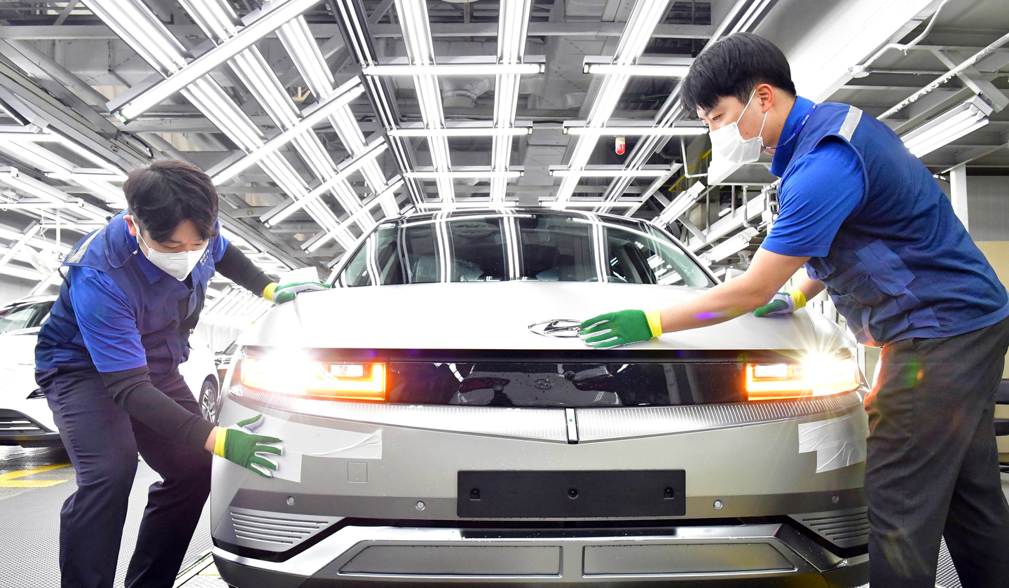 Workers inspect a vehicle on the production line for the Ioniq 5 EV at Hyundai Motor’s Ulsan plant. [HYUNDAI MOTOR]