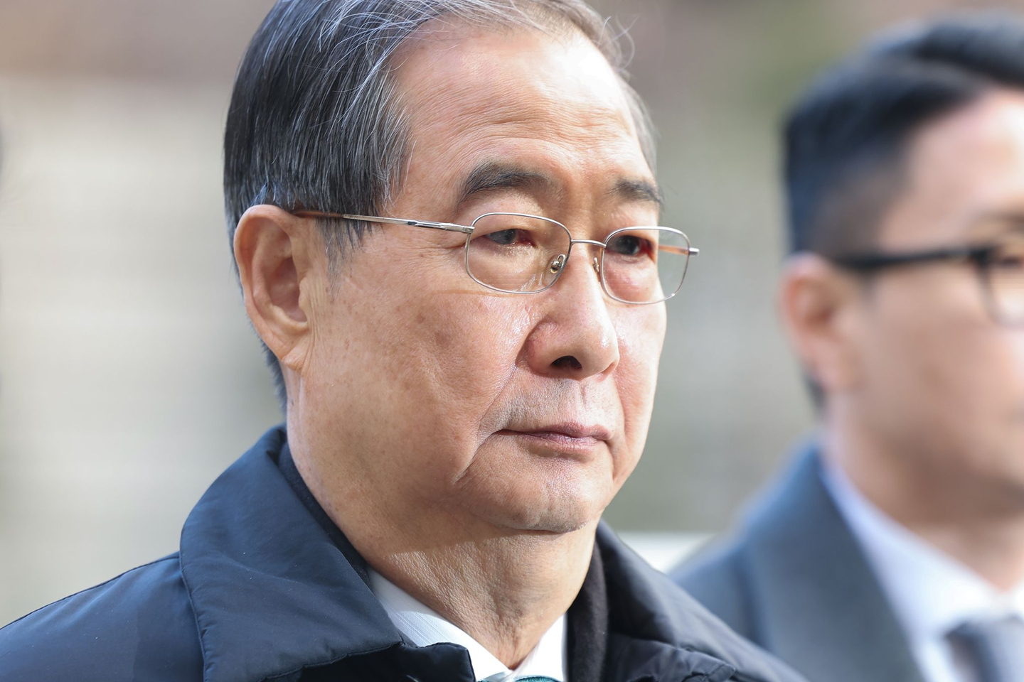Former Prime Minister Han Duck-soo, who is accused of aiding and abetting the alleged ringleader of an insurrection, heads to the courtroom to attend an initial sentencing hearing at the Seoul Central District Court on Jan. 21. [YONHAP]