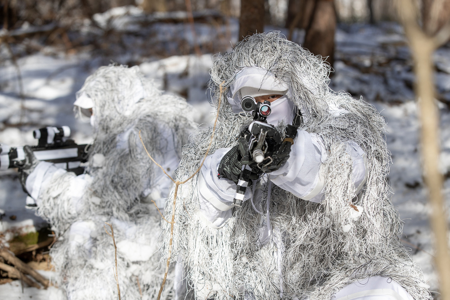 The Army's Special Warfare Command points at a target while concealing themselves using snow, leaves and branches in Gangwon, in this photo provided by the Army on Jan. 22. [ARMY]