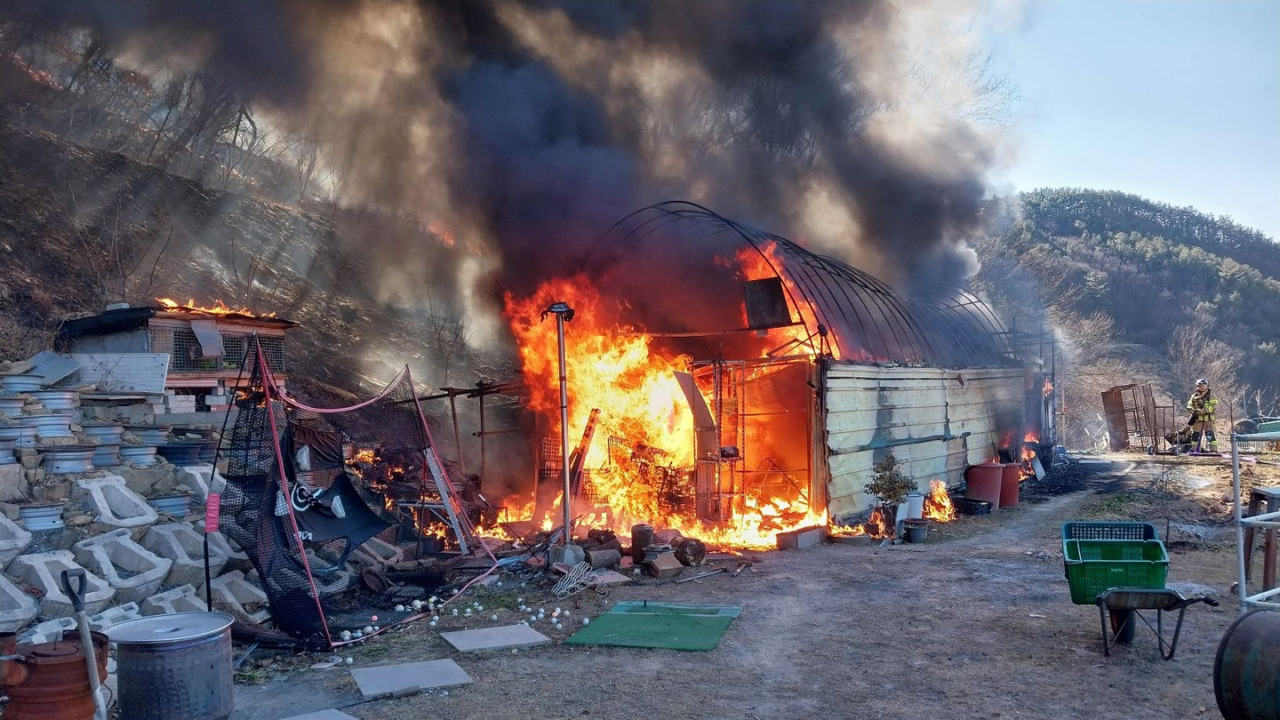 Forestry authorities battle a fire after flames break out at a farm shed used as a storage space in Jiphyeon-myeon, Jinju, South Gyeongsang, and spread to a nearby wooded hill on Jan. 22. [NORTH GYEONGSANG FIRE SERVICE HEADQUARTERS]