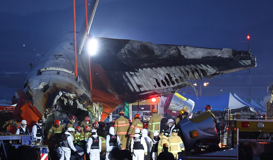 Firefighters and rescue personnel conduct a search operation at the site where a Jeju Air passenger plane crashed at Muan International Airport in South Jeolla on Dec. 29. [YONHAP]