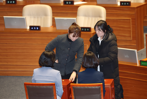 People Power Party Rep. Kim Yea-ji casts her vote on the motion to impeach President Yoon Suk Yeol on Saturday. Kim, the first visually impaired female lawmaker in Korea, left the chamber before the vote but returned with an aide to cast her vote.  [YONHAP]