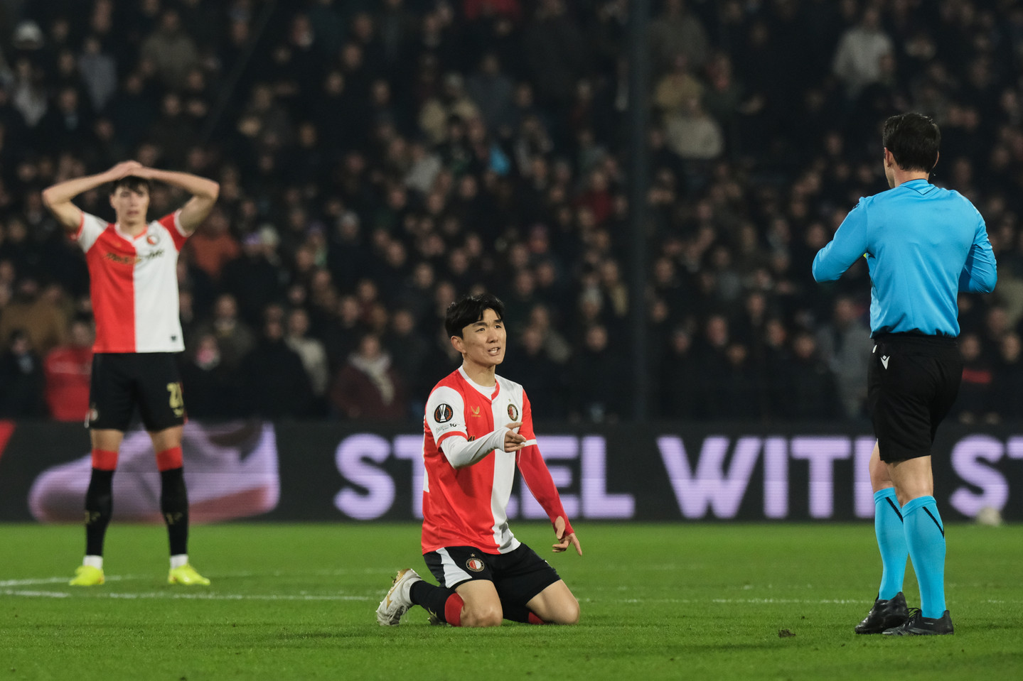 Feyenoord midfielder Hwang In-beom, center, receives a yellow card during the Europa League opening phase match against SK Sturm Graz in Rotterdam, the Netherlands, on Jan. 22. [AP/YONHAP] 