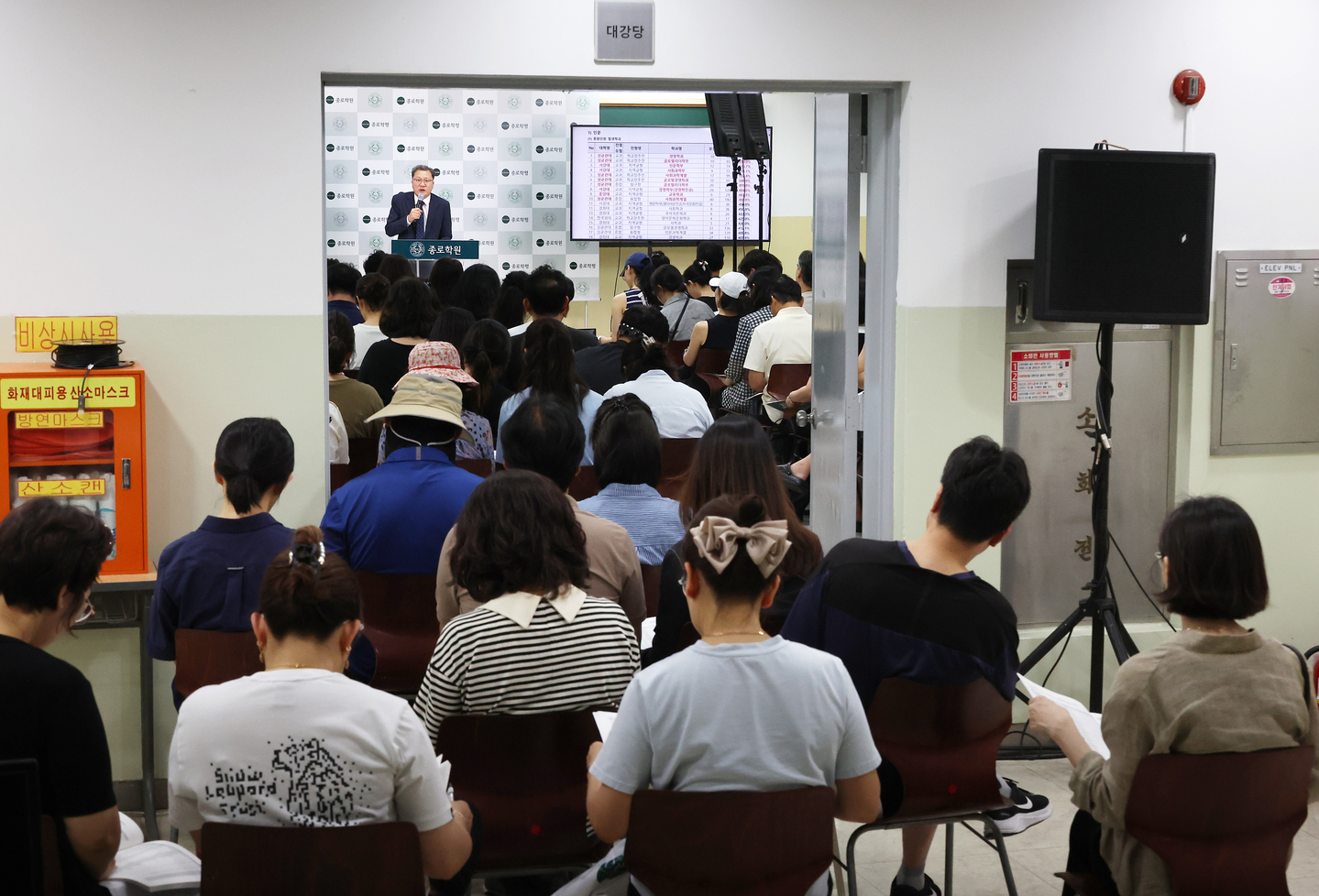 Parents and students listen to a special admissions strategy session for 2026 college admissions held at a cram school in the Daechi-dong neighborhood of Gangnam District, southern Seoul, on July 27, 2025. [YONHAP]