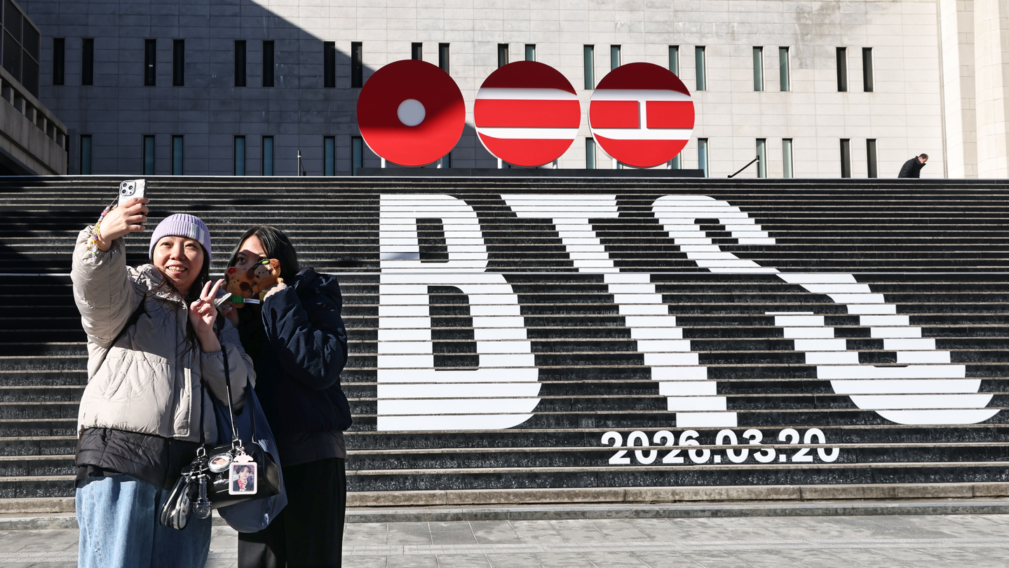 People take photos in front of a promotional installation announcing boy band BTS's comeback in front of Sejong Arts Center in Jongno District, central Seoul, on Jan. 22. [YONHAP]