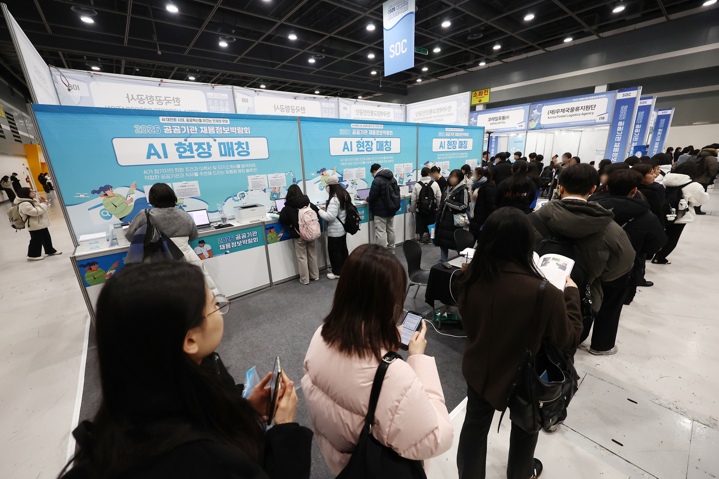 Visitors stand in line in front of a booth that uses AI to match people with jobs at the “2026 Public Sector Job Fair” at the aT Center in Seocho District, southern Seoul, on Jan. 27. The job fair, with about 150 public institutions participating, is the first one taking place this year and will last through Jan. 29. [NEWS1]