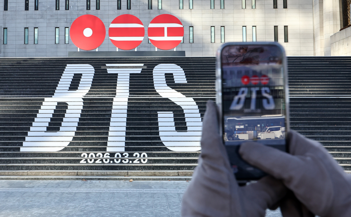 A tourist takes a photo of a promotional installation announcing boy band BTS's comeback set up in front of Sejong Arts Center in Jongno District, central Seoul, on Jan. 22. [NEWS1]
