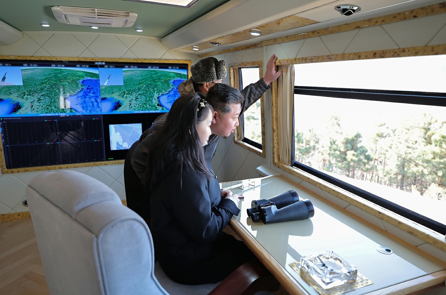 North Korean leader Kim Jong-un, center back, is seen overseeing the test-fire of an upgraded large-caliber multiple rocket launcher system (MRLS) at a facility in North Korea on Jan. 27, in this photo released by the Korean Central News Agency on Jan. 28. [KOREAN CENTRAL NEWS AGENCY]